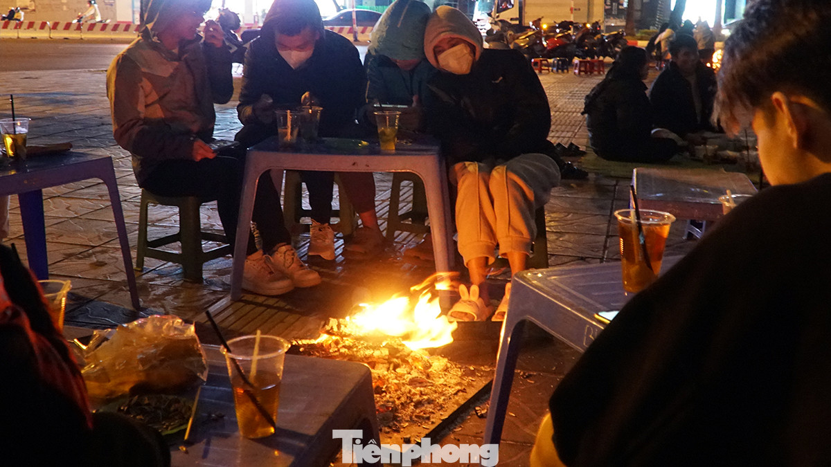 Một số bạn trẻ ngồi kề bên nhau, ăn món ăn dân dã như khoai nước, ngô nướng, uống cốc trà đá vỉa hè để xua đi cái lạnh "cắt da cắt thịt" giữa đêm đông.