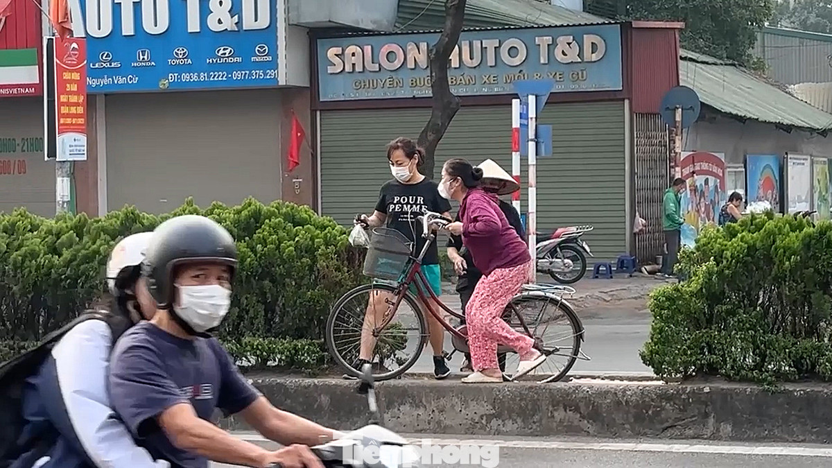 Có người bê cả xe đạp qua dải phân cách để sang đường. Có người bê cả xe đạp qua dải phân cách để sang đường.