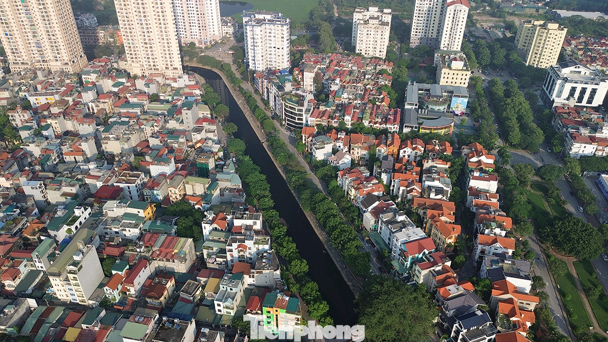 Dòng sông nước đen kịt uốn lượn qua những khu vực dân cư đông đúc.