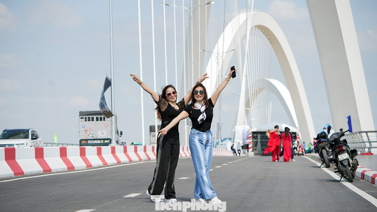Nhiều người tranh thủ ngày đầu khánh thành, các phương tiện tham gia giao thông chưa đi lại nhiều để chụp ảnh "check-in" trên cầu để lưu giữ kỷ niệm.