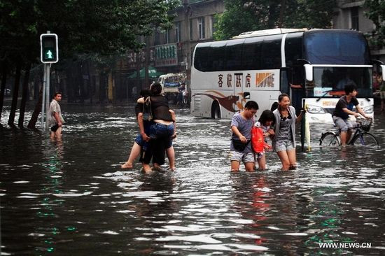 Người băng qua đường ngập nước trong khu Thiết Tây, Thẩm Dương, thủ phủ tỉnh Liêu Ninh, đông bắc Trung Quốc, 16/8/2013. Ảnh: Tân Hoa Xã 