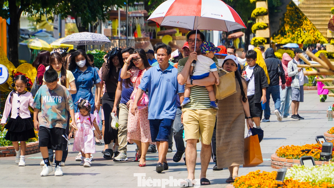 Bất kể trời nắng gắt và thời tiết nóng bức, lượng người đổ về đường hoa mỗi lúc một đông.
