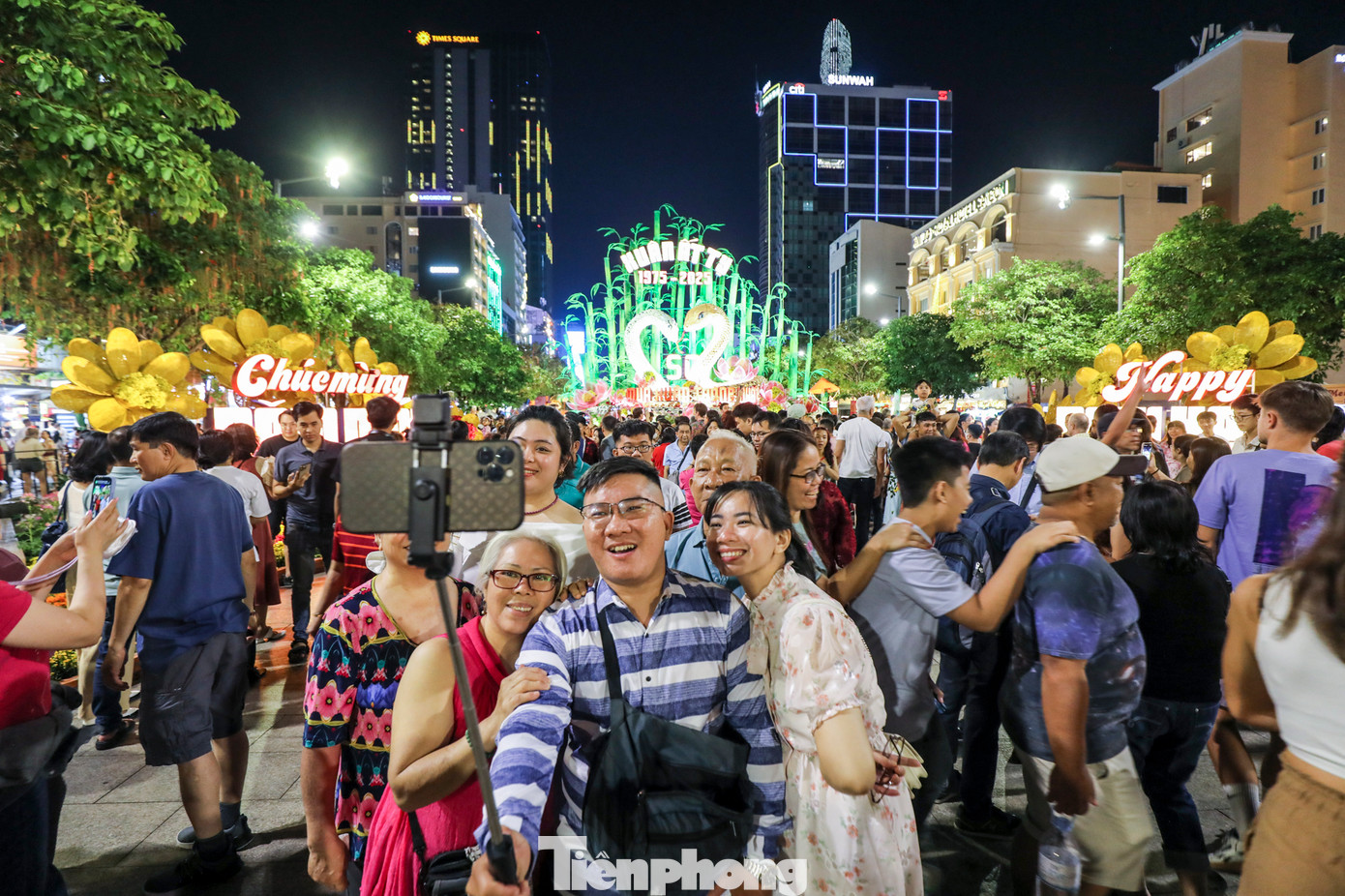 Đường Nguyễn Huệ, phía trước khu vực đường hoa Nguyễn Huệ lúc 22 giờ đông nghẹt người dân ngồi chờ ngắm pháo hoa.