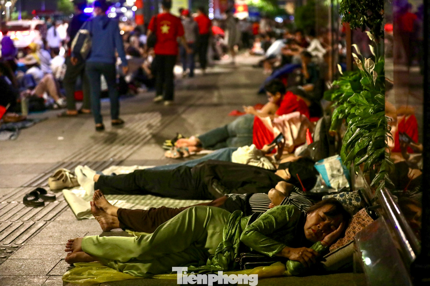 Nhiều người đã quyết định trải bạt nằm trên vỉa hè ở phố đi bộ Nguyễn Huệ chờ được trải nghiệm những khoảnh khắc lịch sử.