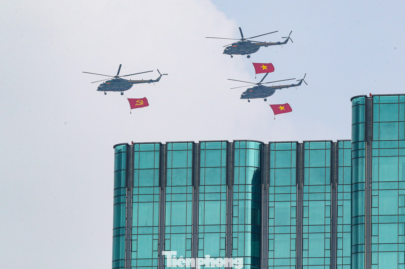 Hình ảnh trực thăng bay trên bầu trời kéo theo cờ Đảng, cờ Tổ quốc.