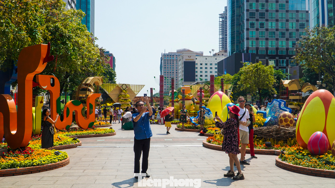 Đến khoảng 12h, khách tham quan vẫn lũ lượt đổ về đường hoa mặc cho thời tiết nắng nóng.