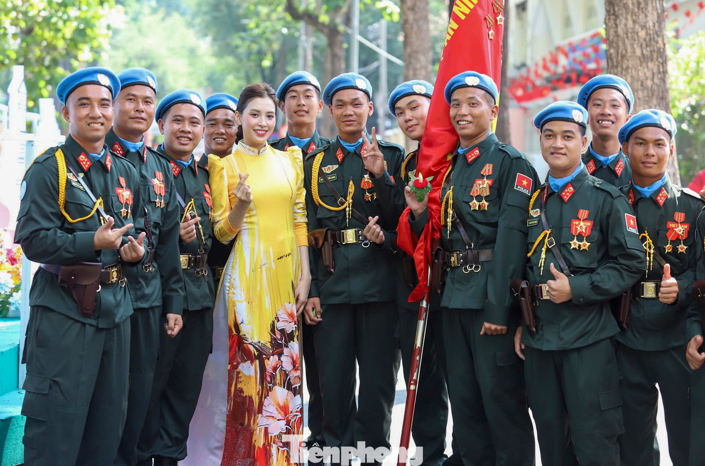 Khối nam lực lượng gìn giữ hoà bình chụp ảnh lưu niệm cùng hoa hậu Tiểu Vy sau buổi tổng duyệt.