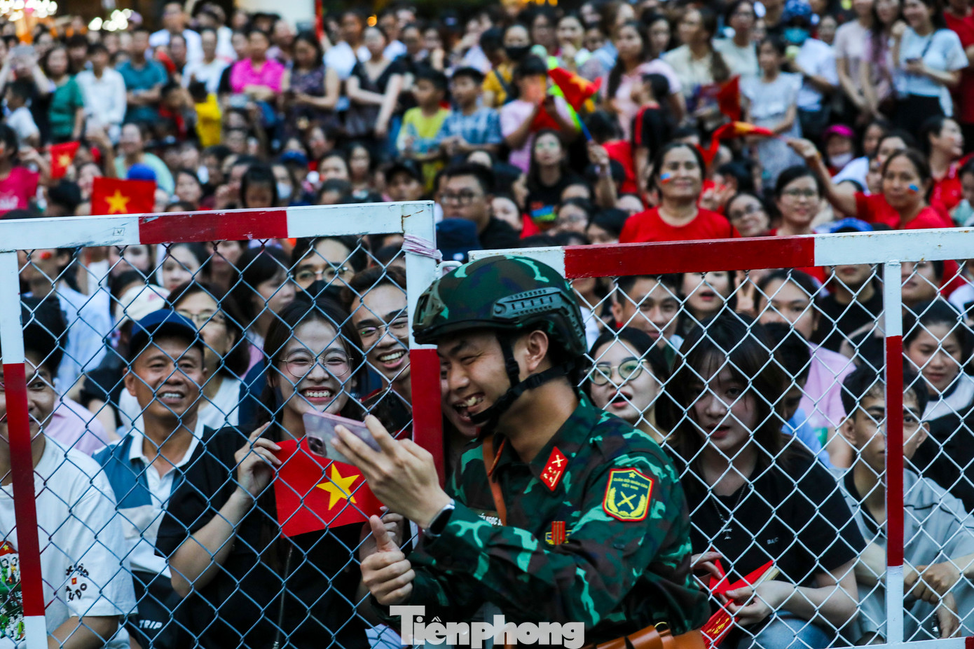 Người dân mang theo cờ, áo đỏ sao vàng, cả những chiếc ghế xếp nhỏ để có thể chờ đợi hàng giờ mong được tận mắt chứng kiến các đoàn diễu binh tiến bước.