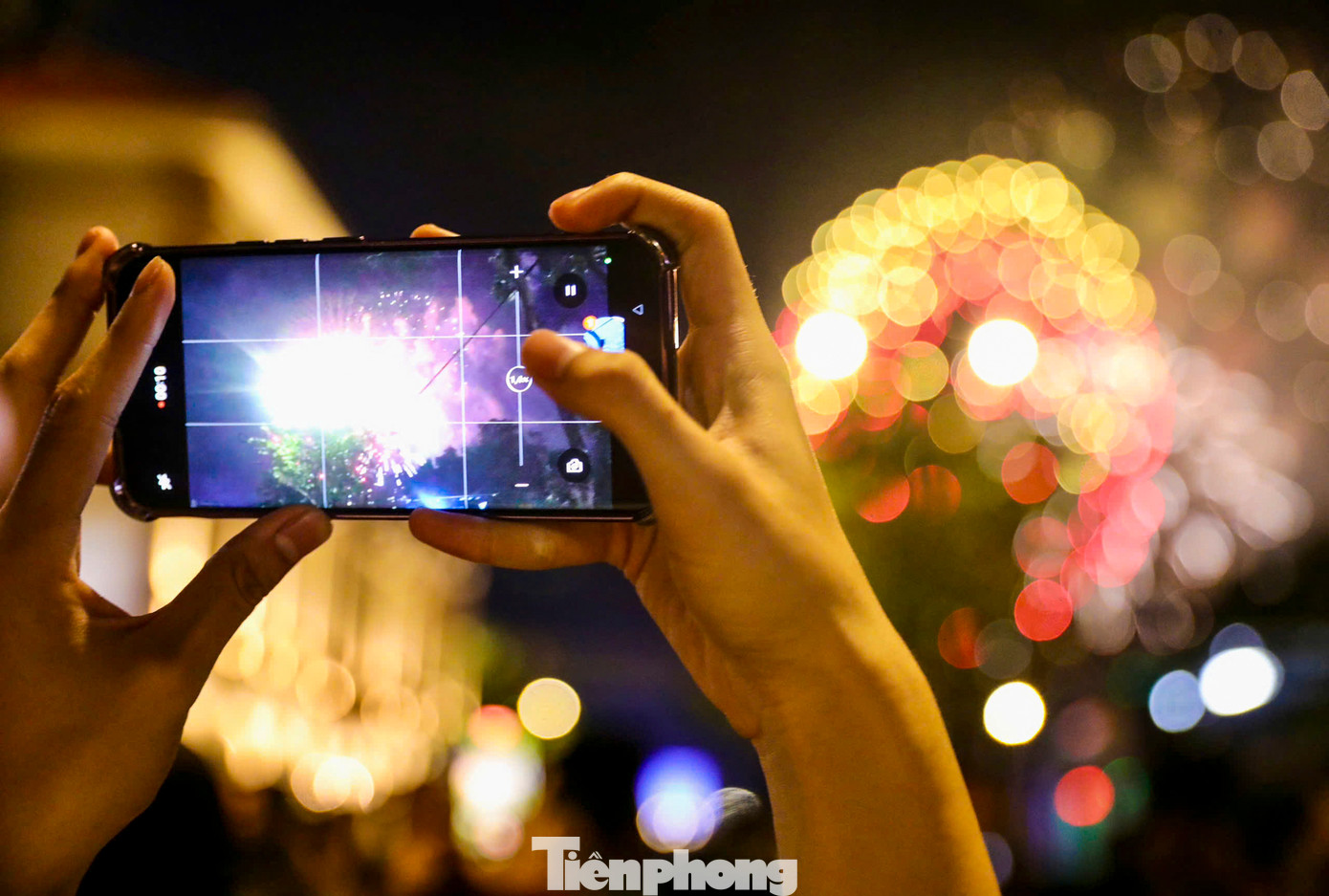 Người dân dùng điện thoại ghi lại khoảnh khắc bắn pháo hoa.