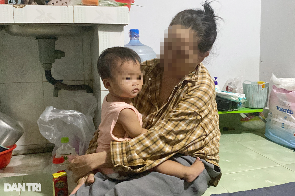 Bà B. bên cạnh đứa cháu ngoại 8 tháng tuổi (Ảnh: An Huy).