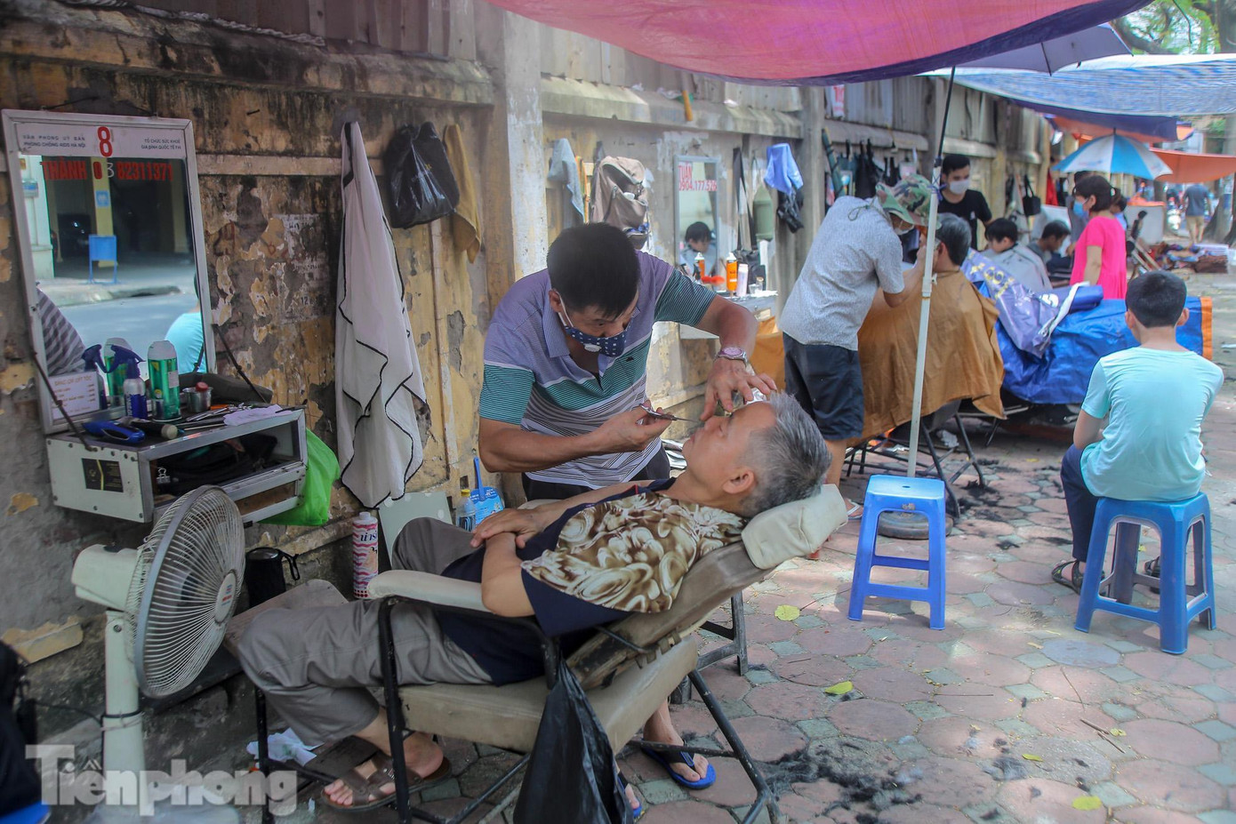 Tiệm cắt tóc vỉa hè trên phố hoạt động hết công suất.
