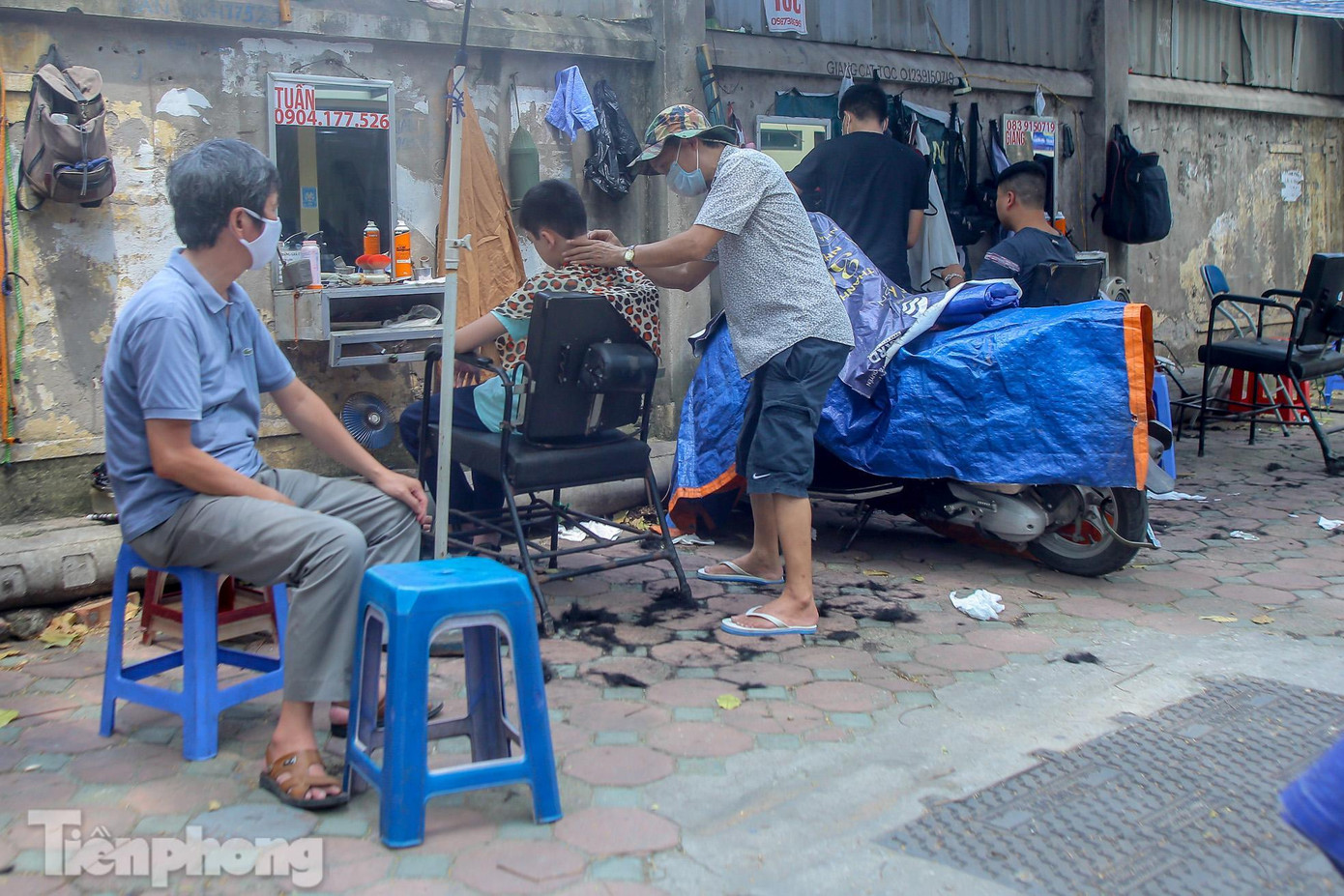 Trên đoạn phố Thái Thịnh, hầu hết các quán cắt tóc vỉa hè đều mở cửa trở lại, người dân Thủ đô ùn ùn kéo đến.