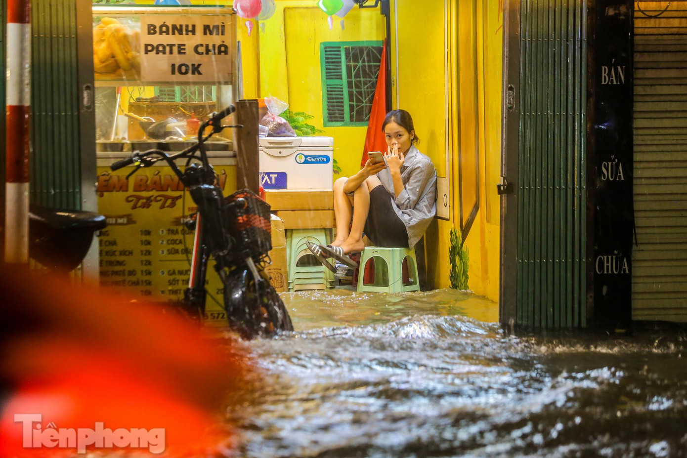 Nước tràn vào nhà mặt phố Tây Sơn chỉ sau ít phút mưa.