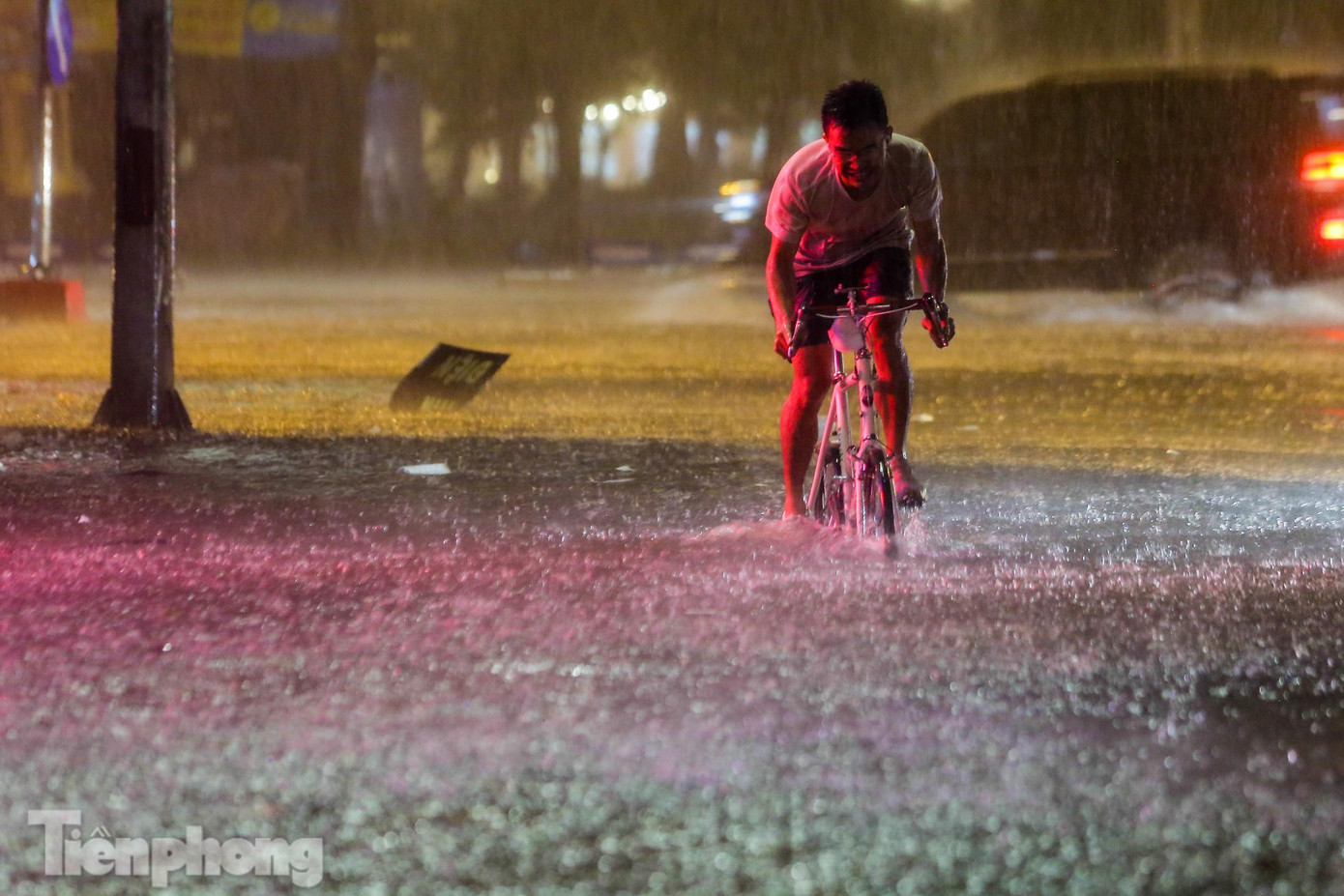 Một người đạp xe nỗ lực qua biển nước.