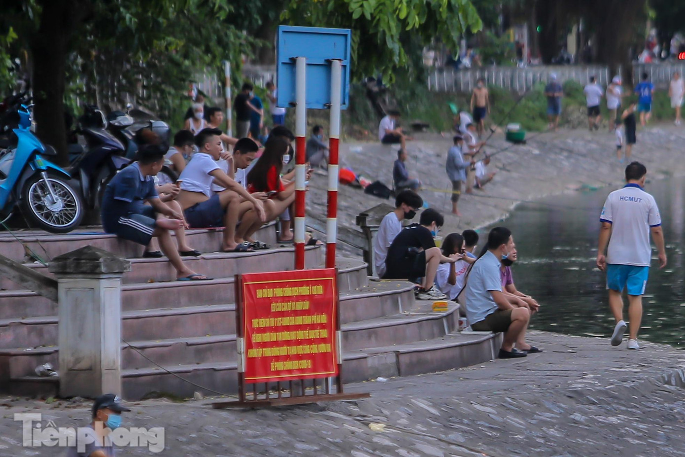 Rất đông người dân tụ tập tại bậc cầu thang xuống đường kè ven hồ, thậm chí có người không đeo khẩu trang.