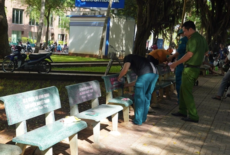 Lực lượng chức năng đang xóa sơn đỏ bôi bẩn trên thành ghế đá.