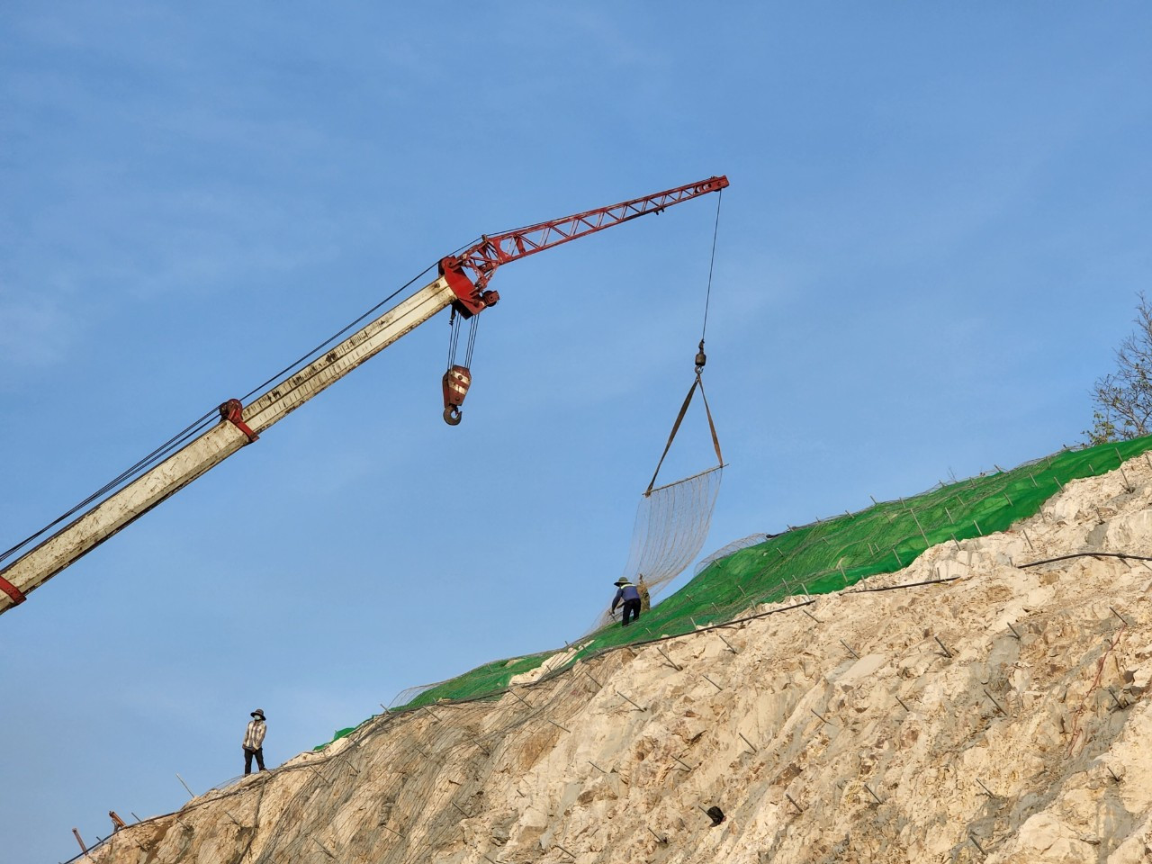 Công nhân đang thi công taluy chống sạt lở trên đỉnh núi. Công nhân đang thi công taluy chống sạt lở trên đỉnh núi.