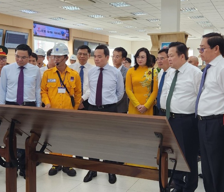 Phó Thủ tướng Trần Lưu Quang và các đại biểu nghe giới thiệu về dự án kho LNG 1 triệu tấn.