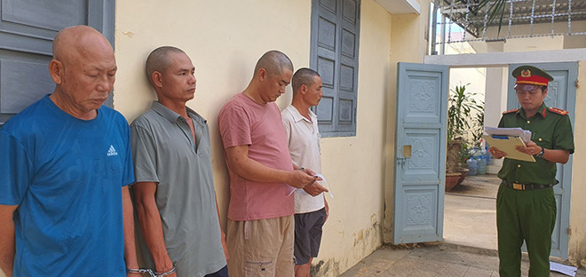 Công an tống đạt quyết định cho các bị can.