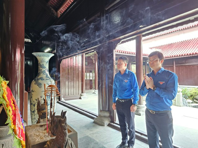 Anh Bùi Quang Huy và anh Nguyễn Kim Quy thắp hương trong lễ giỗ. Ảnh: BTN.