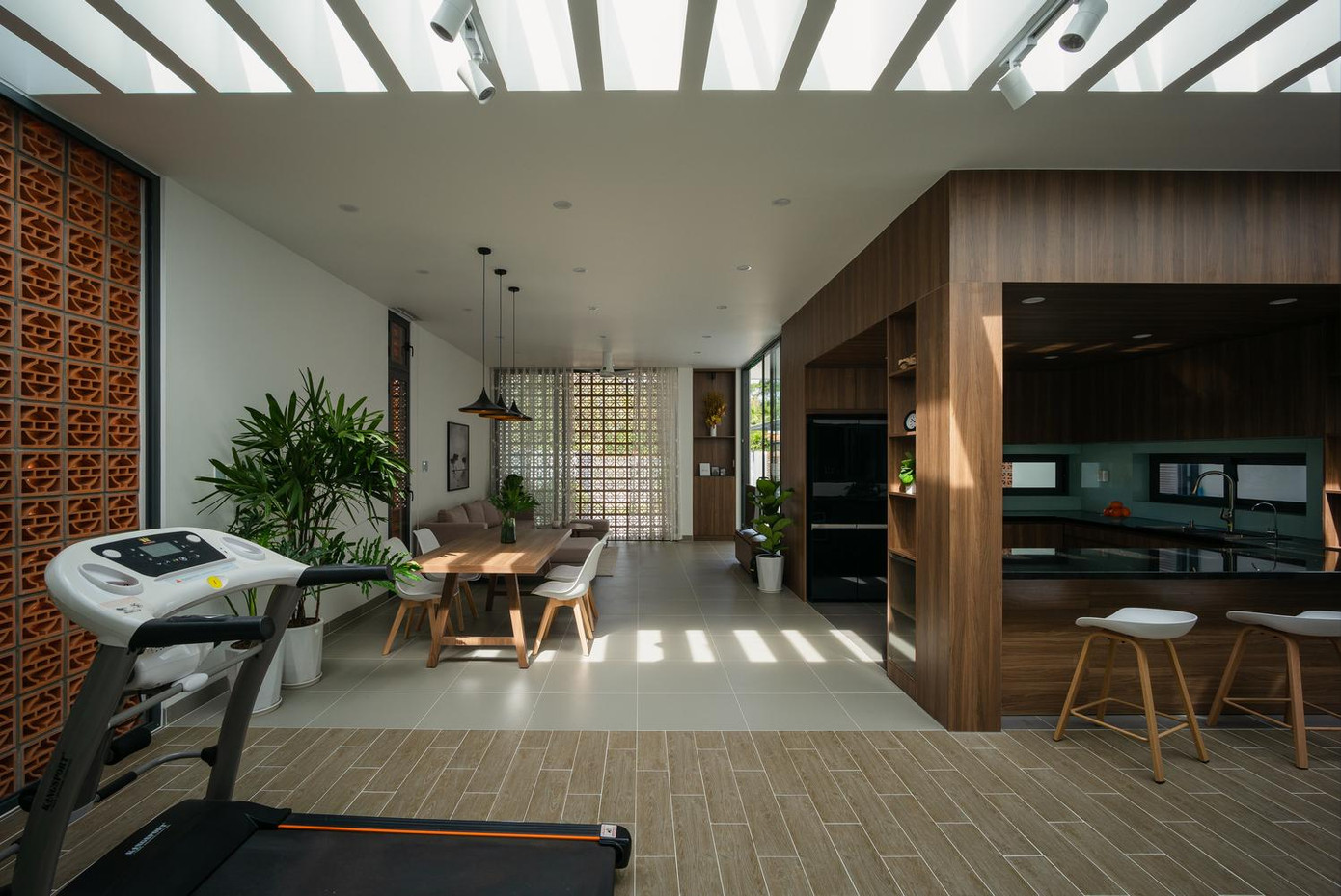 Khoảng sân giữa nhà là không gian gắn kết các thành viên trong gia đình, có công năng linh hoạt, bao gồm góc làm việc, tập thể dục, khu vui chơi cho trẻ nhỏ.