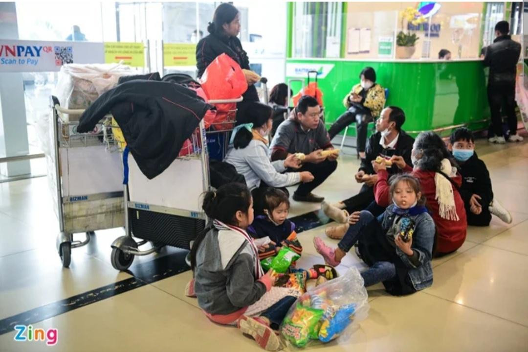 Gia đình 9 người của chị Phạm Thị Mai Loan không tìm được chỗ ngồi khi cả sân bay chật kín người. Đã tới giờ cơm trưa, gia đình đành phải dùng bữa tại chỗ để chờ chuyến bay về TPHCM lúc 12h30.