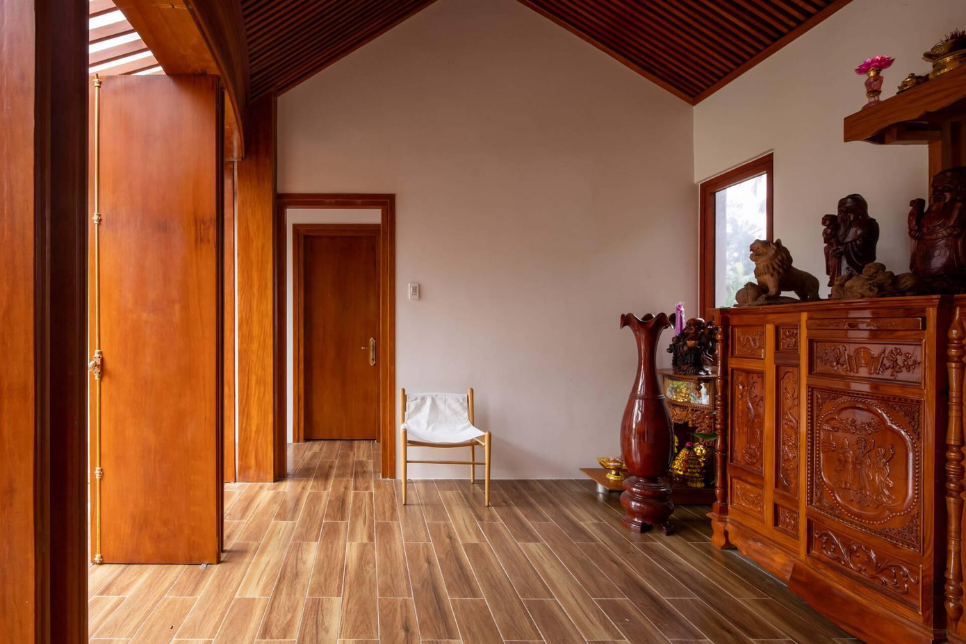 Tại đây, các kiến trúc sư sử dụng gỗ mít ta để làm tường bao kết hợp với vách lam che nắng giúp tổng thể ngôi nhà vừa hiện đại vừa ấm cúng, quen thuộc.