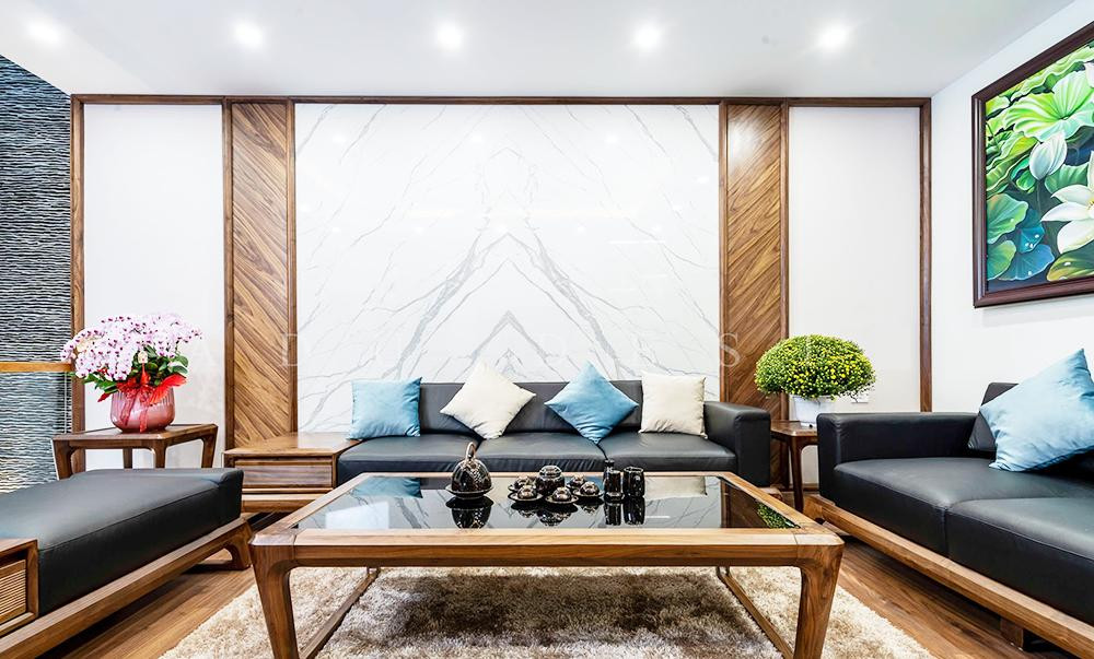 Phòng khách màu trắng kết hợp với bàn, ghế và sàn gỗ mang lại cảm giác sang trọng và ấm cúng.