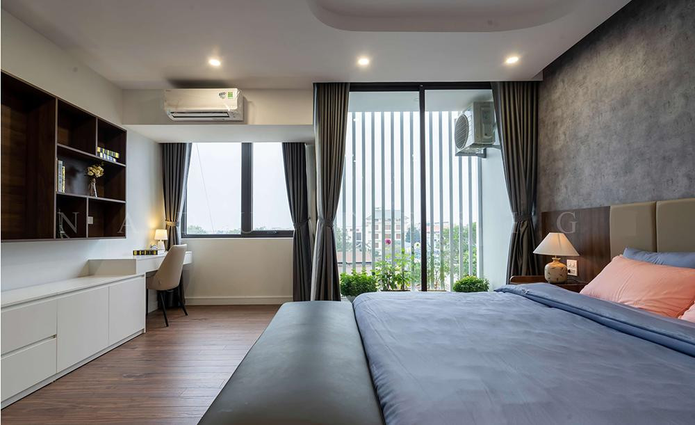 Không gian phòng ngủ của bố mẹ có một ban công trồng hoa, cây cảnh và bàn làm việc cạnh cửa sổ.