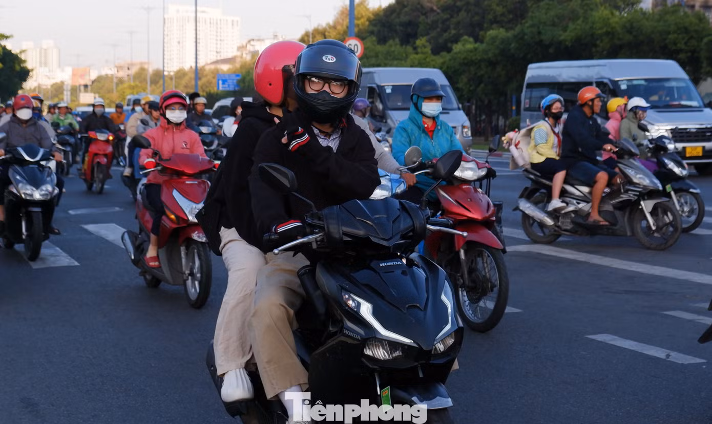 Người đi đường phải khoác thêm áo, đeo bao tay để giữ ấm cơ thể. Ảnh: Hữu Huy