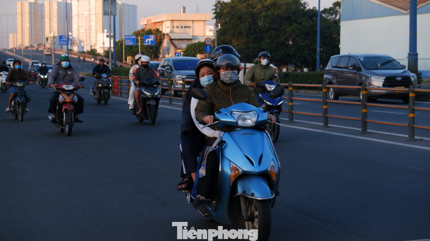 Người đi đường phải khoác thêm áo, đeo bao tay để giữ ấm cơ thể. Ảnh: Hữu Huy
