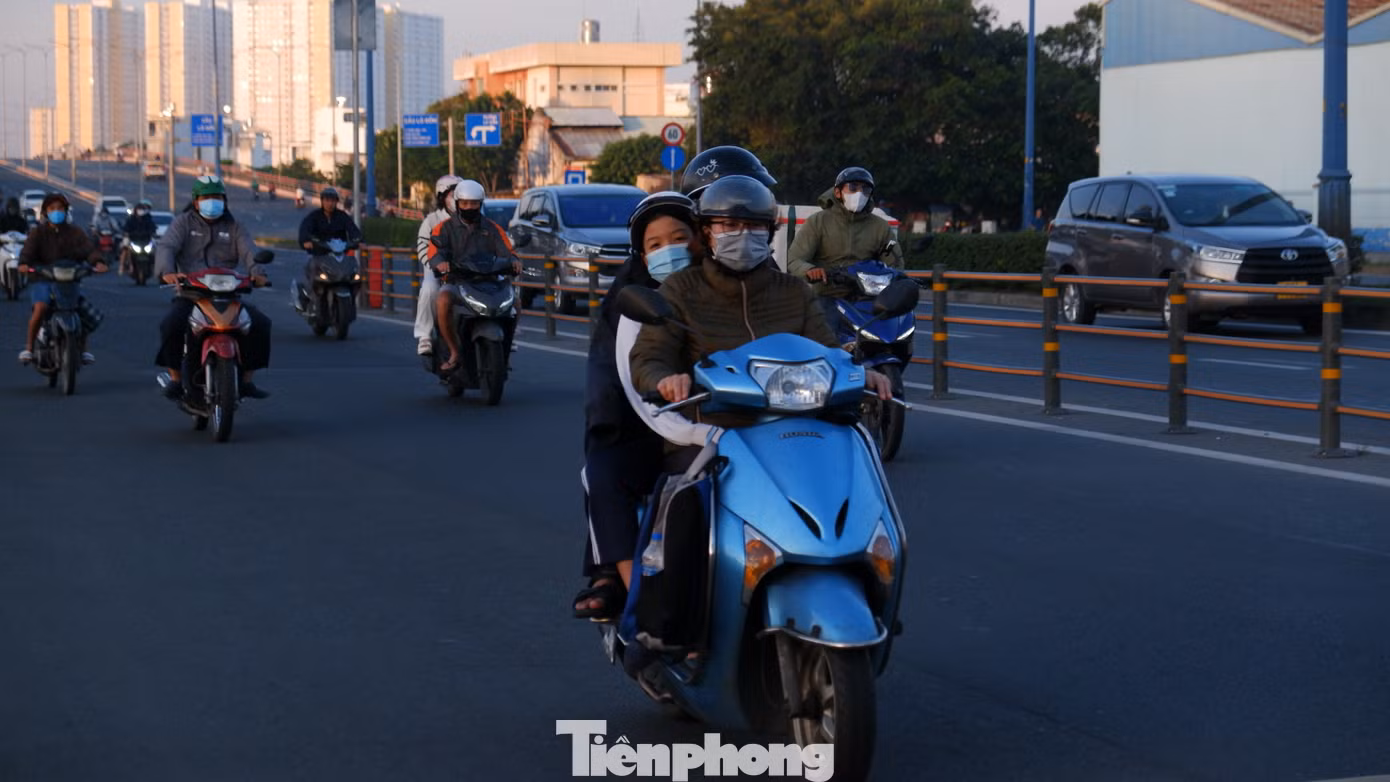 Người đi đường phải khoác thêm áo, đeo bao tay để giữ ấm cơ thể. Ảnh: Hữu Huy