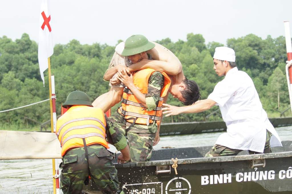 Chiến sĩ Công binh và Quân y đưa khẩn trương đưa người bị nạn lên bờ cấp cứu