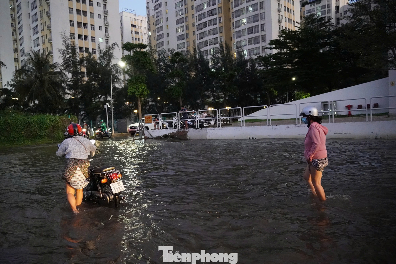 Nước ngập mênh mông ở đường số 14, phường Tân Phong, quận 7 làm một số xe bị &quot;chết máy&quot;, người dân phải bì bõm lội nước dắt xe thoát khỏi điểm ngập.