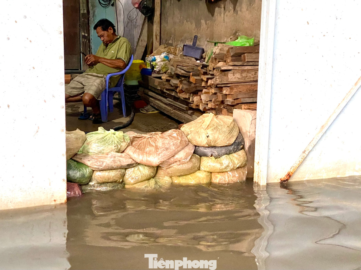 Người dân phải dựng bao cát làm tường ngăn nước tràn vào nhà.
