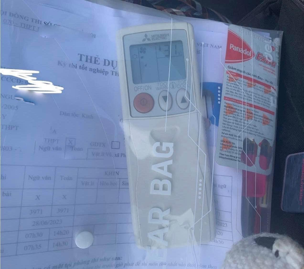 Mang nhầm remote máy lạnh thay vì máy tính, còn vỉ thuốc giảm đau hẳn là để tỉnh táo khi đọc đề nhỉ? Ảnh: Trường Người ta. Mang nhầm remote máy lạnh thay vì máy tính, còn vỉ thuốc giảm đau hẳn là để tỉnh táo khi đọc đề nhỉ? Ảnh: Trường Người ta.