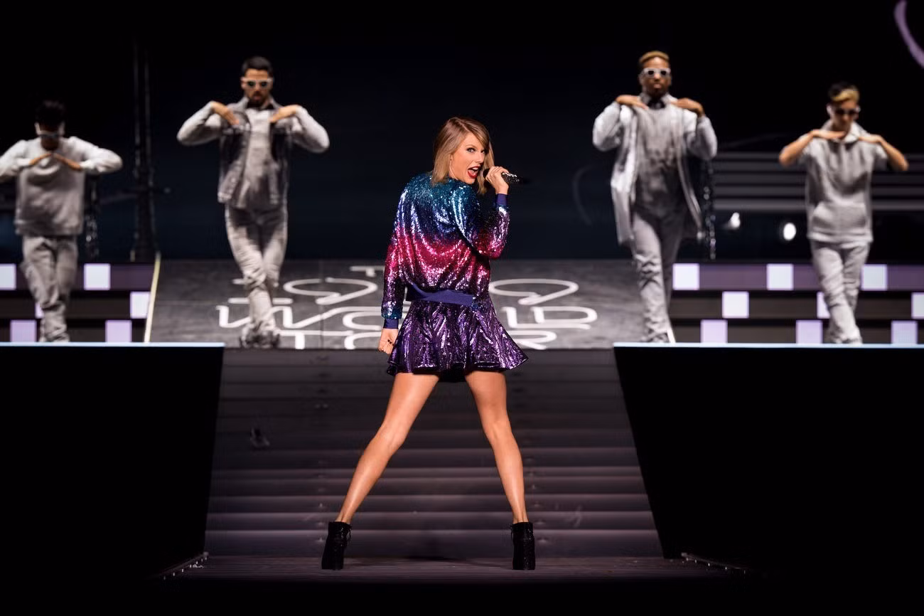 Taylor Swift không ngại diện đồ sặc sỡ khi bắt đầu chuyến lưu diễn vòng quanh thế giới 1989 với váy lấp lánh và áo khoác nhiều màu.