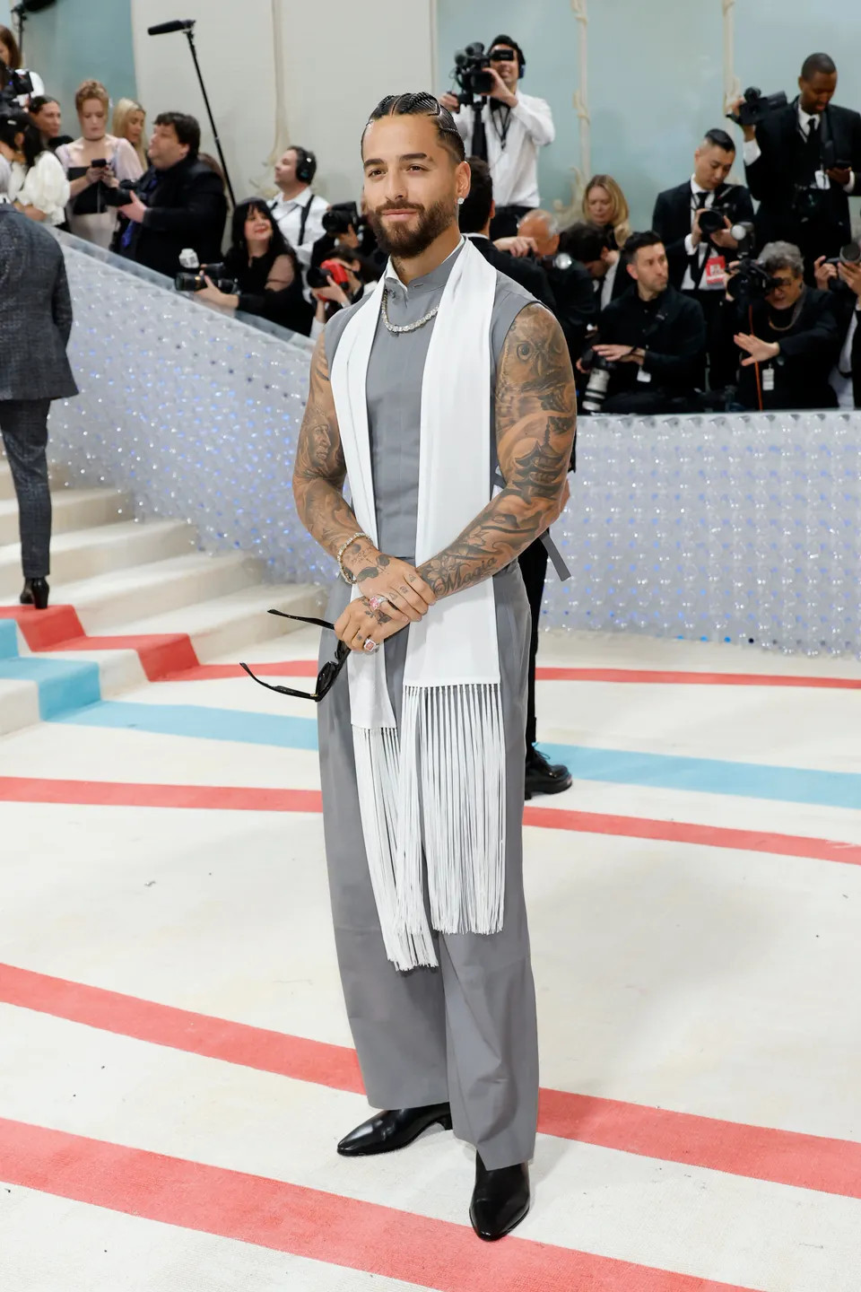 Trai đẹp Maluma xuất hiện lạ mắt cùng set đồ không tay, kèm khăn quàng trắng và kính râm.