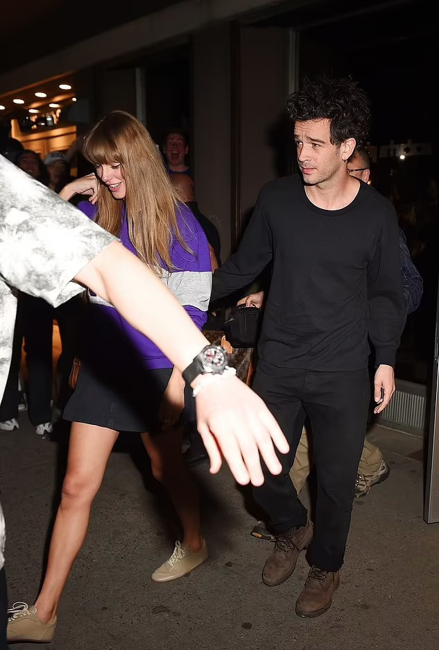 Thành viên nhóm 1975 đặt tay lên lưng Taylor Swift. Thành viên nhóm 1975 đặt tay lên lưng Taylor Swift.