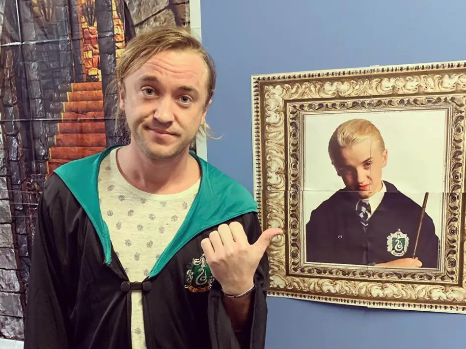 Tom Felton chụp với bức hình của chính mình thuở còn là thiếu niên trong vai Draco Malfoy.