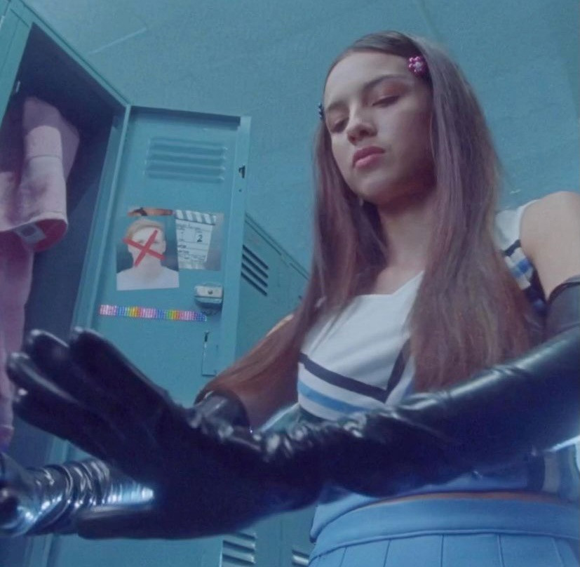 Trong MV good 4 u, Olivia Rodrigo diện găng tay latex phối với đồng phục nữ sinh tạo sự tương phản dữ dội nhưng rất cá tính. Trong MV good 4 u, Olivia Rodrigo diện găng tay latex phối với đồng phục nữ sinh tạo sự tương phản dữ dội nhưng rất cá tính.