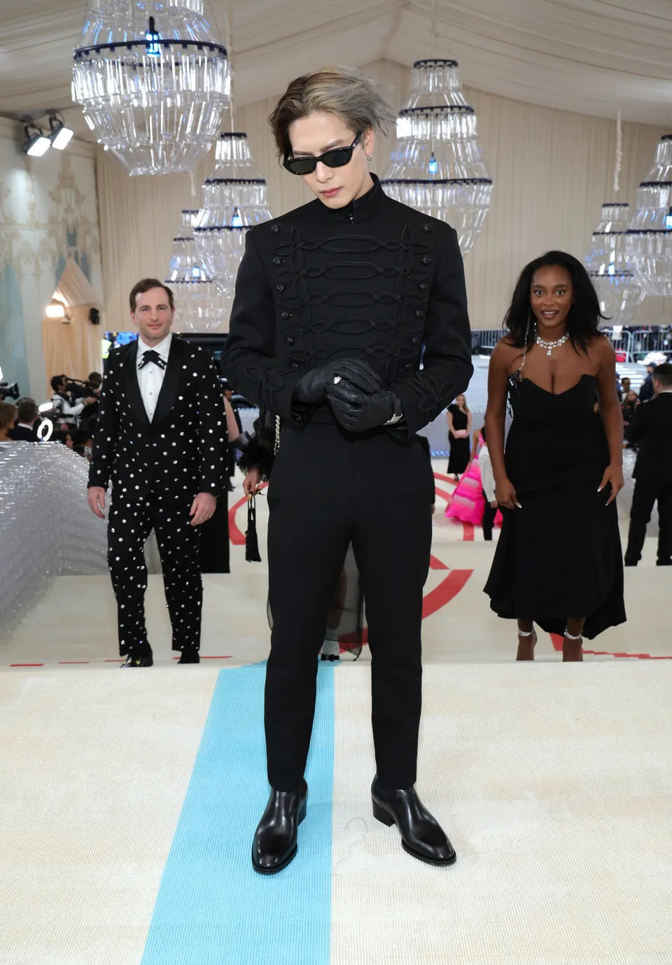 Jackson Wang lần đầu tham dự Met Gala với nguyên một cây đen và mái tóc tẩy hai màu được đánh rối. Kiểu tạo hình tóc này gợi nhớ tới kiểu tóc của nhà thiết kế quá cố.