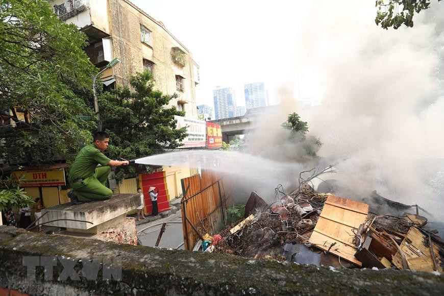 Lực lượng chức năng nỗ lực dập tắt đám cháy. (Ảnh: Hoàng Hiếu/TTXVN)