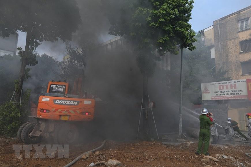 Lực lượng chức năng nỗ lực dập tắt đám cháy. (Ảnh: Hoàng Hiếu/TTXVN)