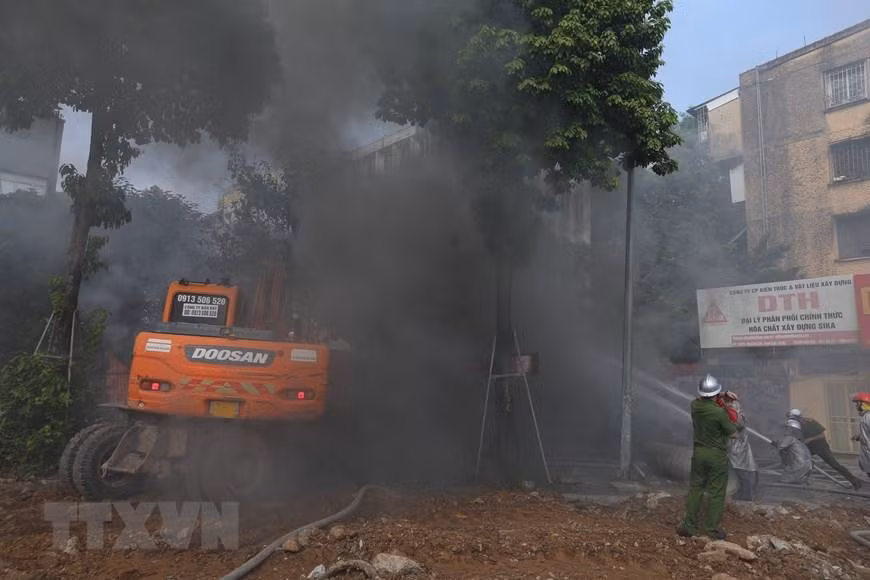Lực lượng chức năng nỗ lực dập tắt đám cháy. (Ảnh: Hoàng Hiếu/TTXVN)
