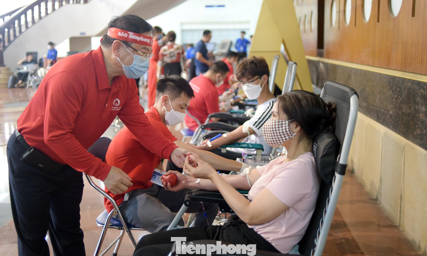 Nhà báo Lê Xuân Sơn tặng huy hiệu nhóm máu cho người hiến máu. Ảnh: Xuân Tùng