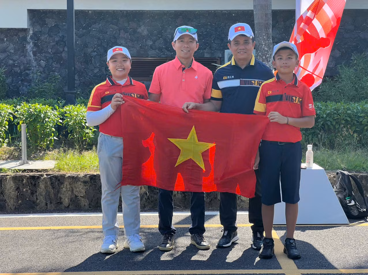 Trưởng đoàn Nguyễn Tuấn Cường (áo đen) và HLV Bạch Cường Khang (áo đỏ) cũng hai VĐV Nguyễn Quốc Bảo Huy và Nguyễn Gia Khôi.