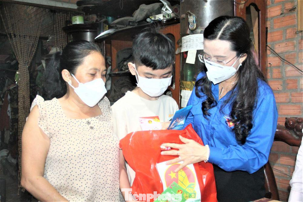 Chị Nguyễn Phạm Duy Trang tặng quà cho bé Nguyễn Tiến Đạt mồ côi cha do dịch bệnh, hiện bé đang ở cùng bà