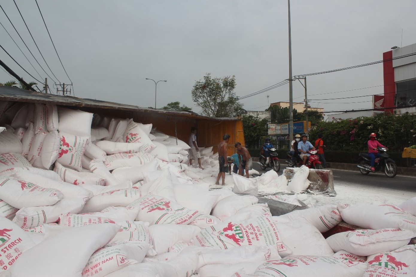 Hàng chục bao hàng tràn xuống đường