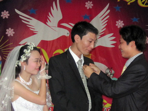 Đôi uyên ương hạnh phúc trong đám cưới đơn sơ mà ấm cúng và vui tươi tại “Phòng cưới văn hóa” xã Ngư Lộc. Ảnh: Hà Đồng